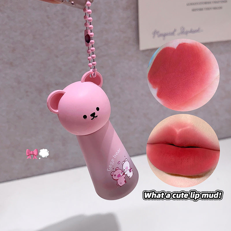 Pink lip mud product with bear design and keychain, inset images of lips.