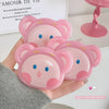 Hand holding two pink bear-shaped containers with a heart and paw print design.