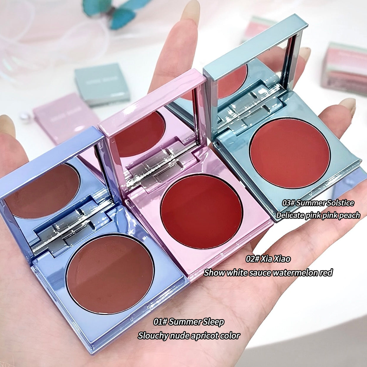 Three open blush compactes with different colors held in a hand.