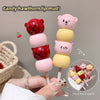 Candy hawthorn lip mud on sticks with cartoon animal faces held by a hand.