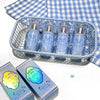 Basket of small bottles with silver caps on a blue and white checkered tablecloth
