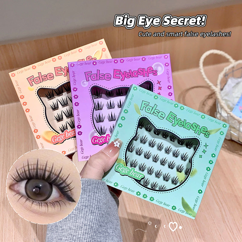 False eyelashes packaging with a hand holding one, on a wooden surface.