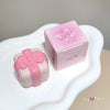 Pink and white decorative item with a bow on a white surface
