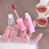 Pink lip gloss with applicator held in hand, close-up of lips with gloss applied.