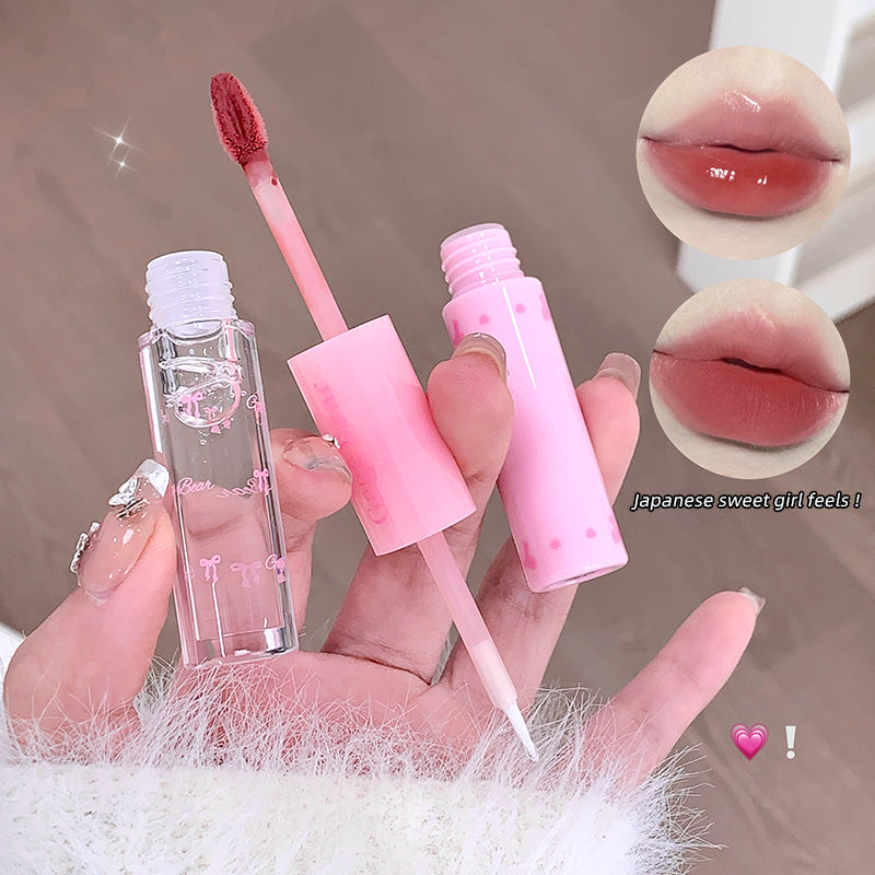 Pink lip gloss with applicator held in hand, close-up of lips with gloss applied.