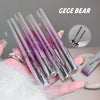 Set of GEGE BEAR lip glosses held in a hand with a blurred background