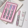 Set of lip glosses with a pink box on a light surface