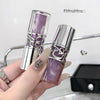 Purple lip gloss with silver cap held by a hand, blurred background