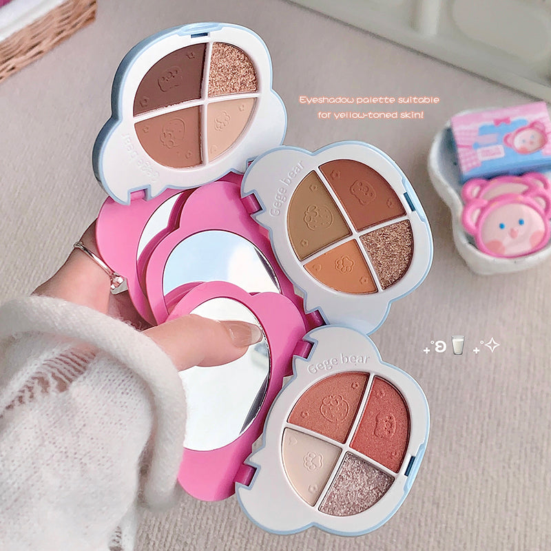 Makeup palette with pink and white case held by a person, with another similar palette in the background.