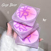 Stack of Gege Bear branded makeup products held by a hand against a neutral background