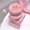 Pink cosmetic product with bear design on a white background