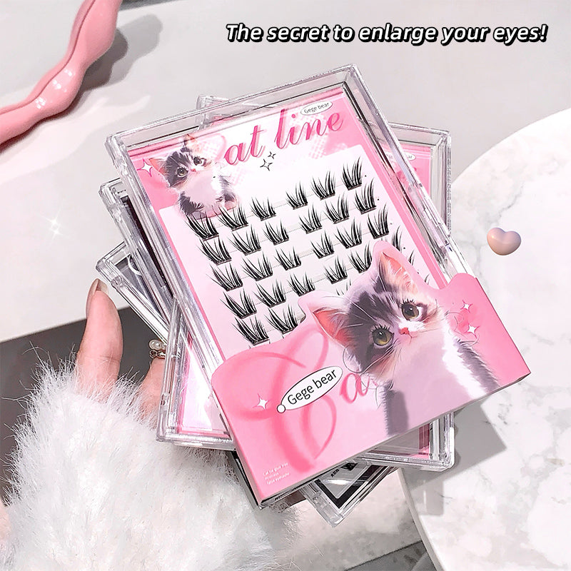 Set of false eyelashes with a pink case featuring cat illustrations on a white surface.