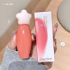 Star-shaped lip gloss with packaging held by a hand on a neutral background