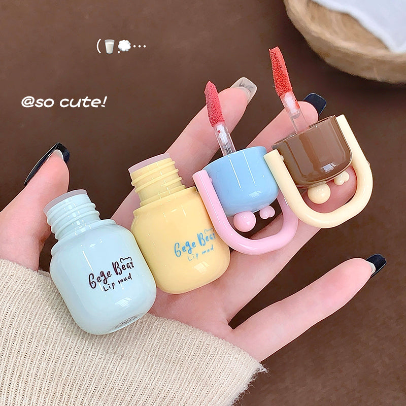 Set of small nail polish bottles with colorful caps held in a hand against a brown background.