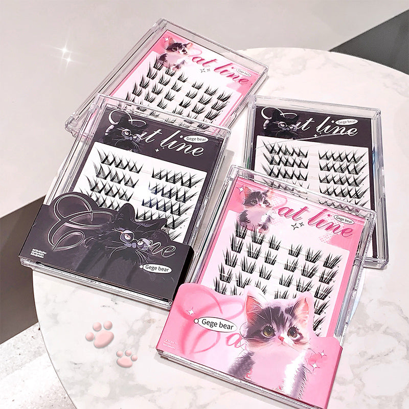 Set of false eyelashes in clear packaging with pink and black design on a white surface.