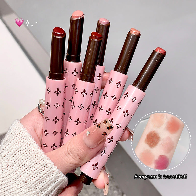 Set of pink lipsticks with decorative patterns held by a hand, with an inset showing lipstick swatches.