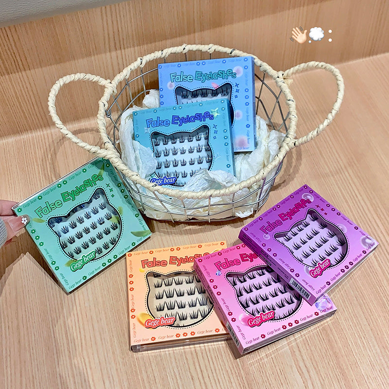 False eyelashes in colorful boxes on a wooden surface with a basket.