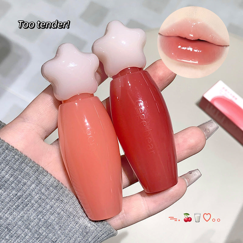 Two star-shaped lip balms held by a hand with a close-up of a glossy lip.