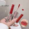 Red lip gloss with applicator held by a hand, showing close-up of lips with gloss applied.