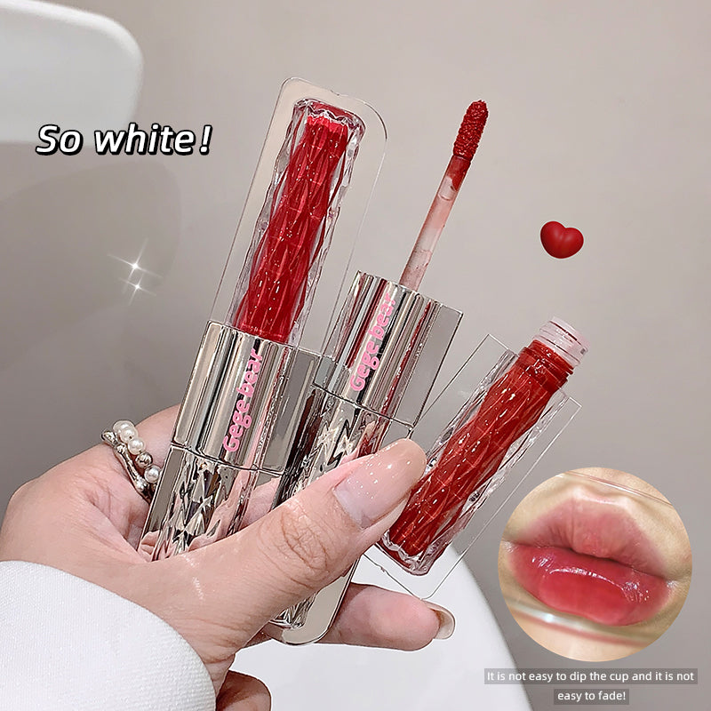 Red lip gloss with applicator held by a hand, showing close-up of lips with gloss applied.