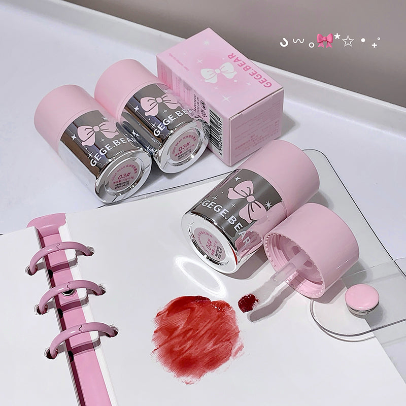 Pink nail polish bottles with a bow design on a white surface