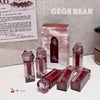 Collection of GEGE BEAR lip products on a white surface with a gray background