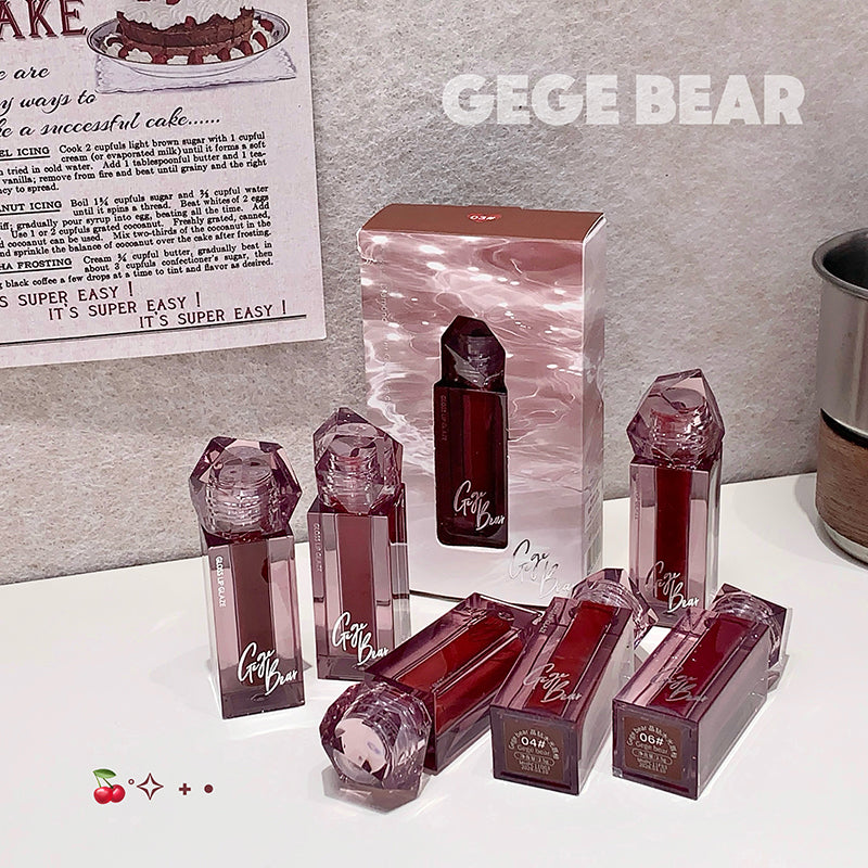 Collection of GEGE BEAR lip products on a white surface with a gray background