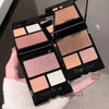 Makeup palette with various shades held by a hand