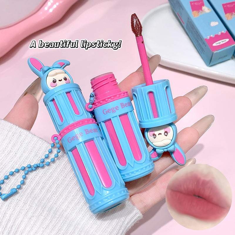Blue and pink lipstick with a cute design held by a hand, on a pink background.