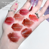 Hand with various shades of lipstick swatched on a white background