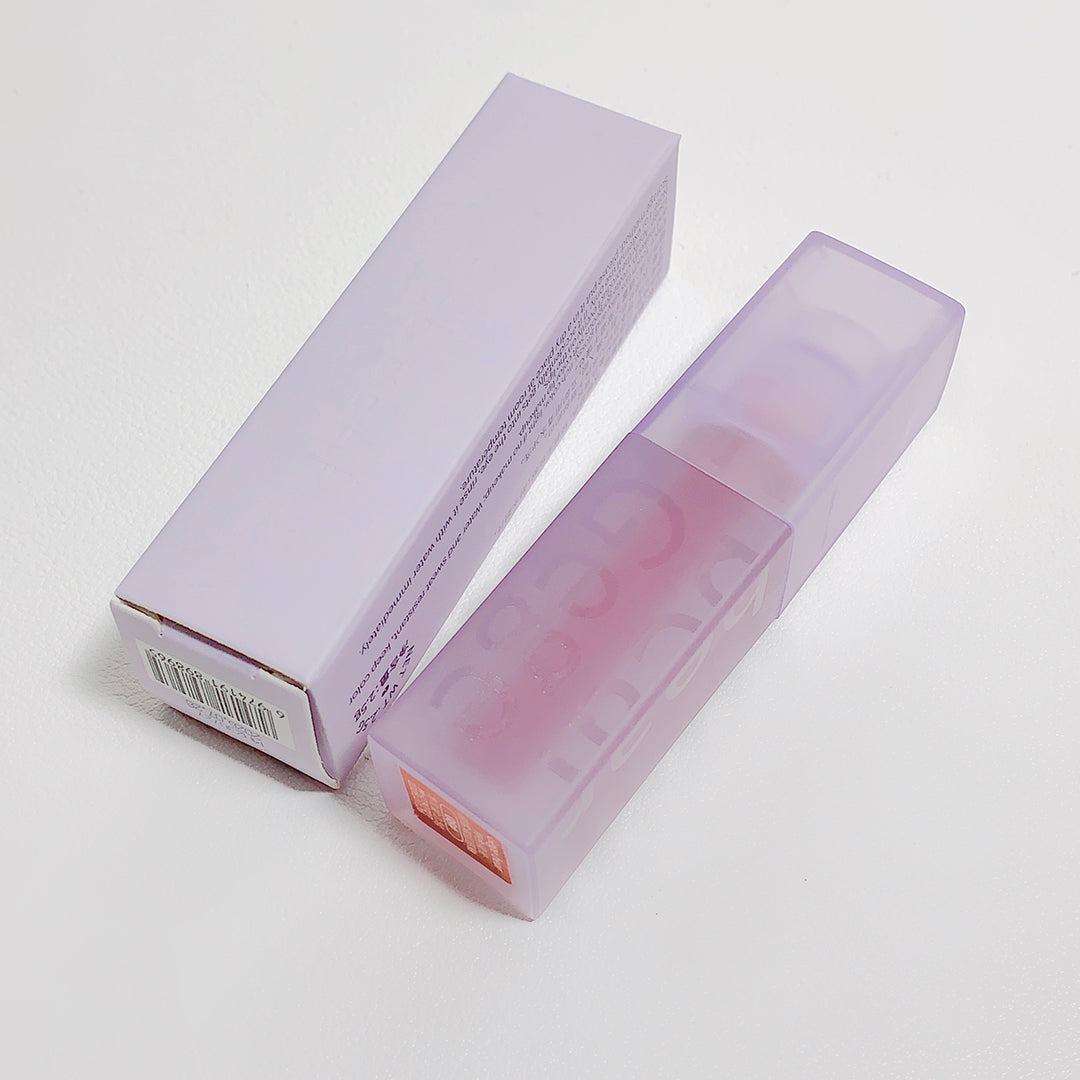 Lavender lip balm with packaging on a light gray background