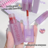 Purple lip gloss with applicator held by a hand, text overlay on a light gray background