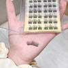 Set of false eyelashes with a clear case held in a hand.