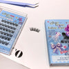 False eyelashes in a box with a pair on a white surface