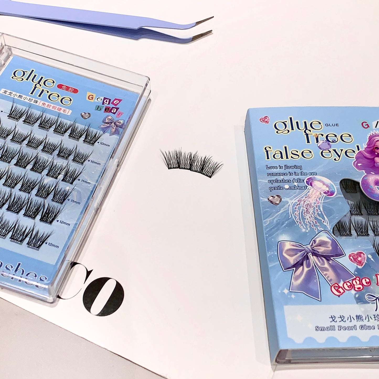 False eyelashes in a box with a pair on a white surface
