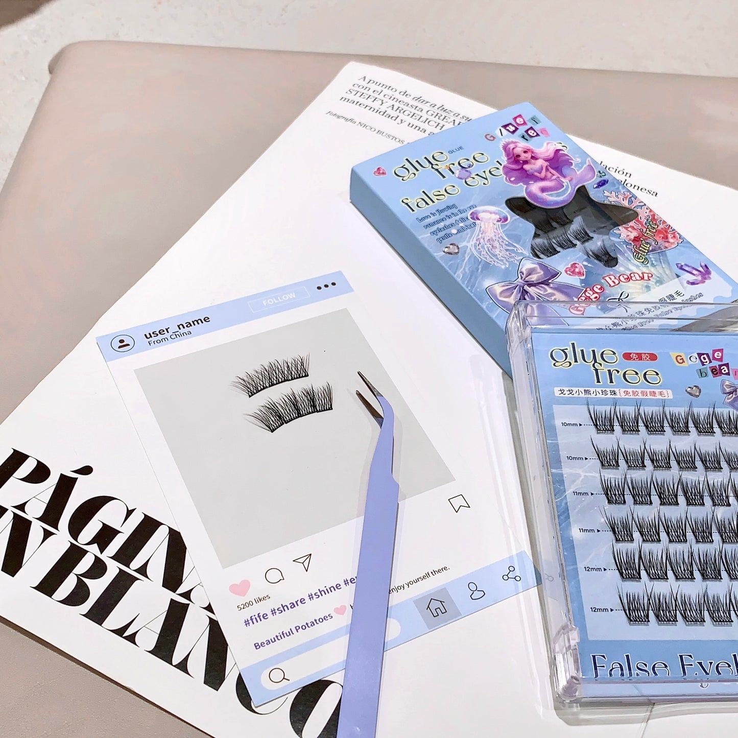 False eyelashes with packaging and a tool on a magazine