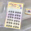 Eyelash extension set with 'glue free' label on a clear stand.