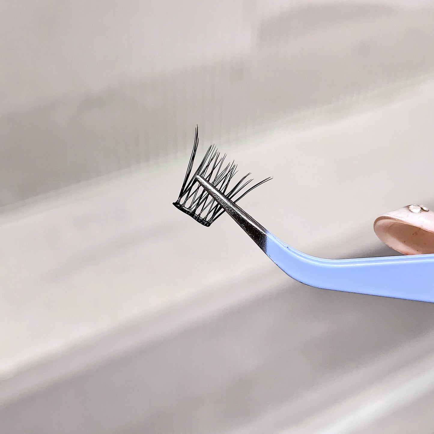 Eyelash extension tool with false eyelashes on a white background