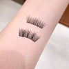 False eyelashes on a person's arm with a neutral background