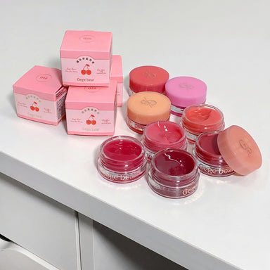 Pink cosmetic jars and boxes with 'Gee Bear' branding on a white surface.