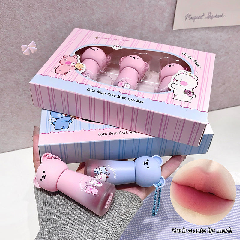 Pink and blue lip masks with bear designs in a box on a gray surface.