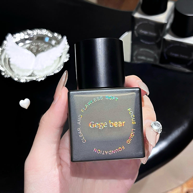 Hand holding a Gege bear foundation bottle with blurred background