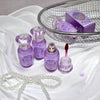 Purple cosmetic products on a white fabric background