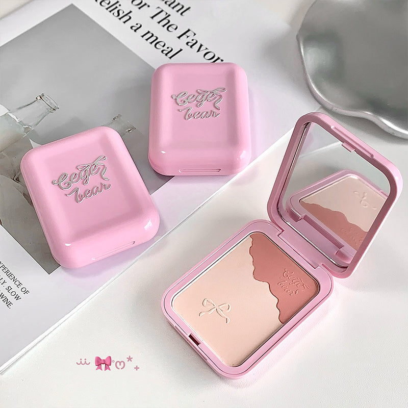 Pink makeup compact with mirror and blush on a white surface
