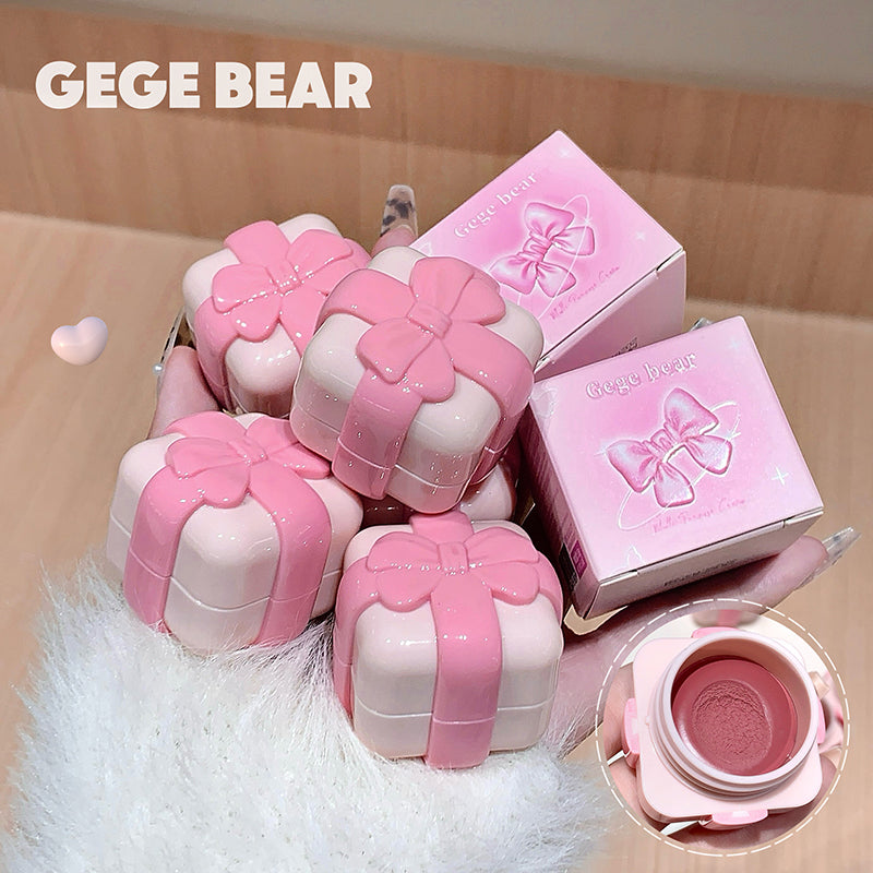 Pink and white cosmetic cases with bow designs, branded 'GEGE BEAR', on a light wooden surface.