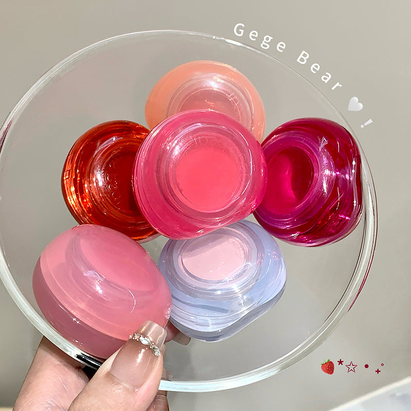 Colorful lip balm containers on a clear stand with 'Gege Bear' branding.
