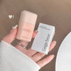 Hand holding a Gege bear concealer bottle and its packaging against a neutral background