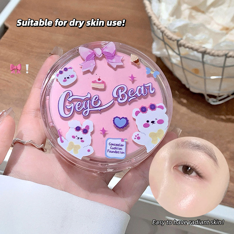 Pink compact foundation case with 'Gege Bear' branding held by a hand, on a wooden surface.