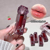 Lip gloss with a decorative cap held by a hand, close-up of lips with gloss, and additional lip glosses in the background.