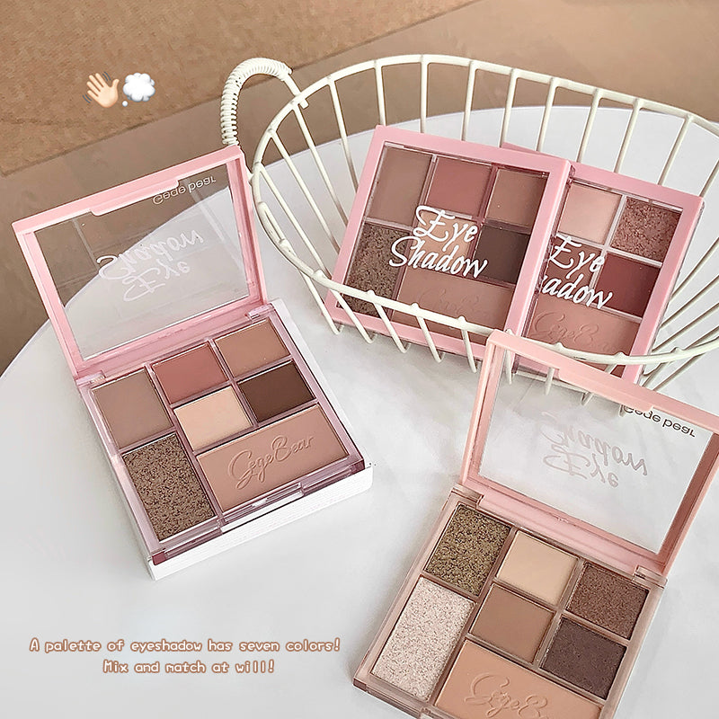 Makeup eyeshadow palettes with a pink case on a white surface